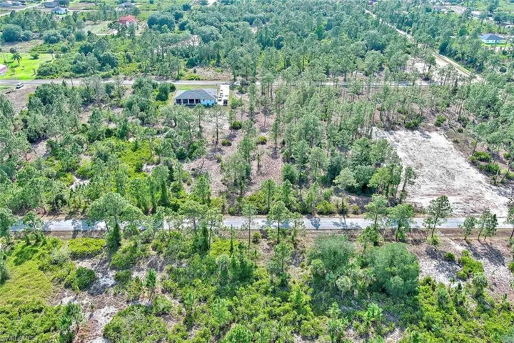 Aerial view of property's location with a heavily wooded area