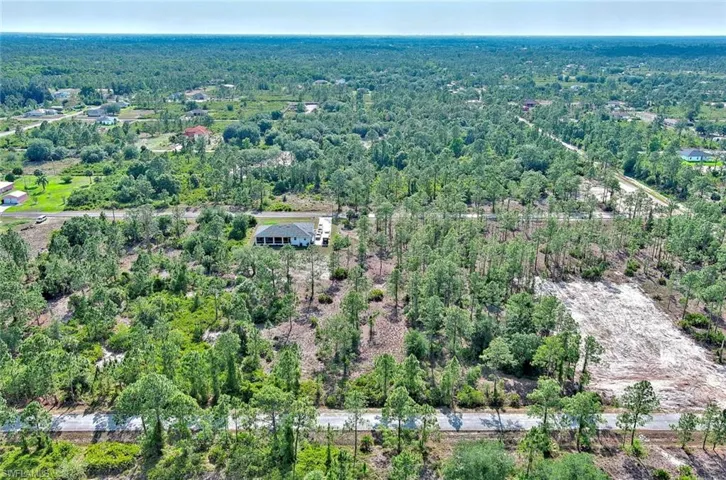 Aerial view of property's location with a heavily wooded area
