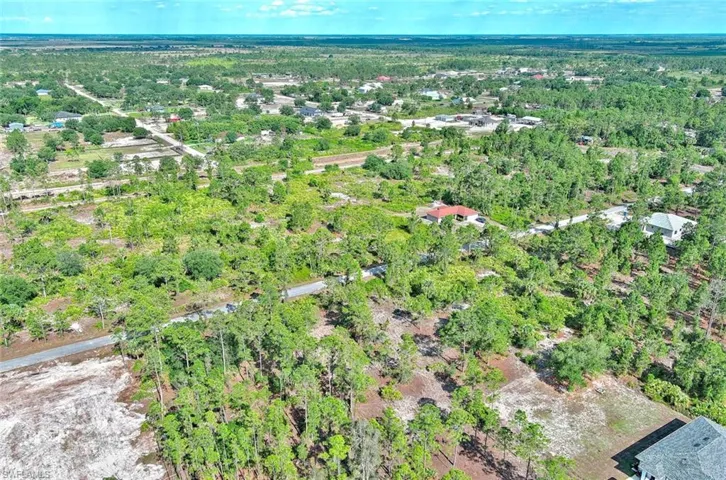 Aerial view of property's location with a heavily wooded area