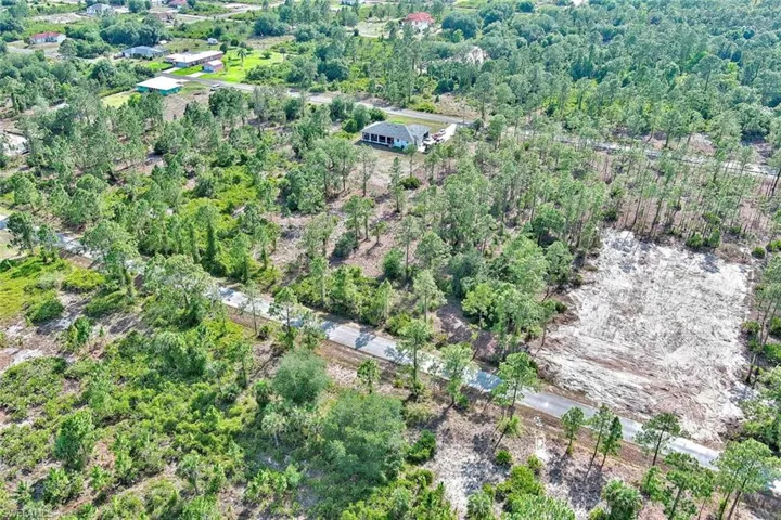 Aerial view of property's location with a heavily wooded area