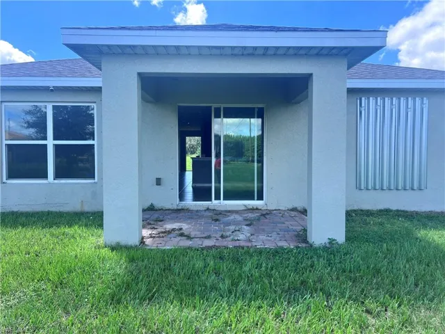 Rear view of house with a patio and a yard