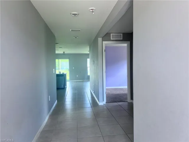 Corridor featuring light tile patterned floors