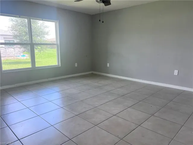 Spare room with ceiling fan and light tile patterned floors