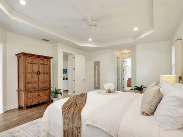 Bedroom featuring ornamental molding, a raised ceiling, ceiling fan, and dark wood-type flooring
