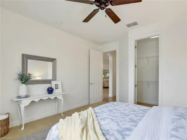 Bedroom featuring ceiling fan, light colored carpet, and a closet