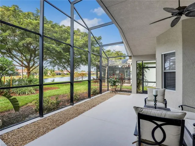 Sunroom / solarium featuring ceiling fan and a water view