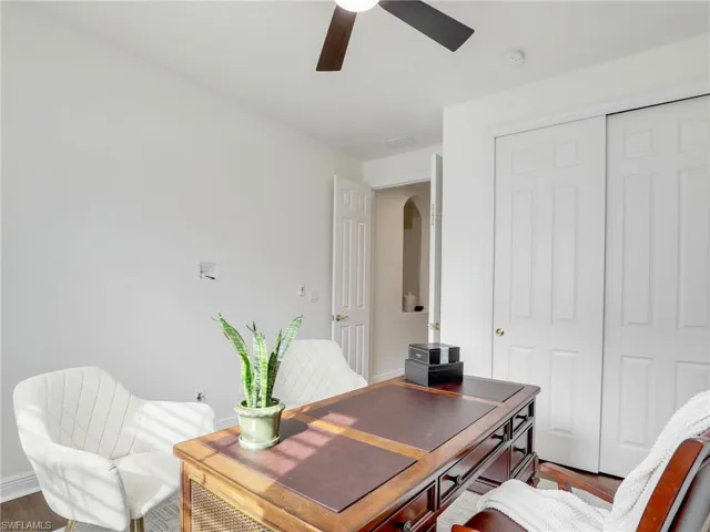 Office area with hardwood / wood-style flooring and ceiling fan