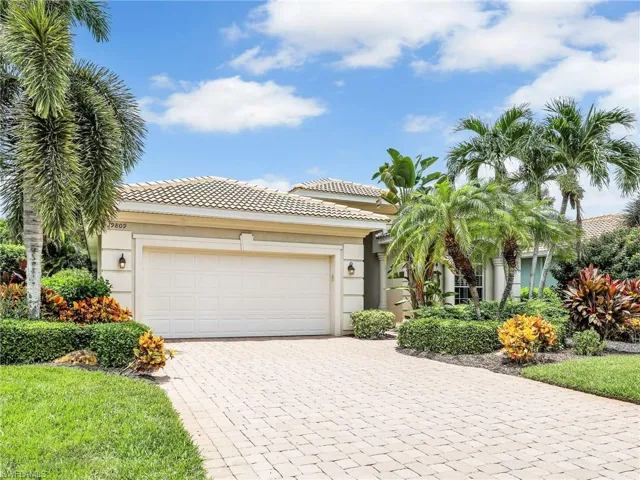 View of front of property featuring decorative driveway, an attached garage, a tile roof, and stucco siding