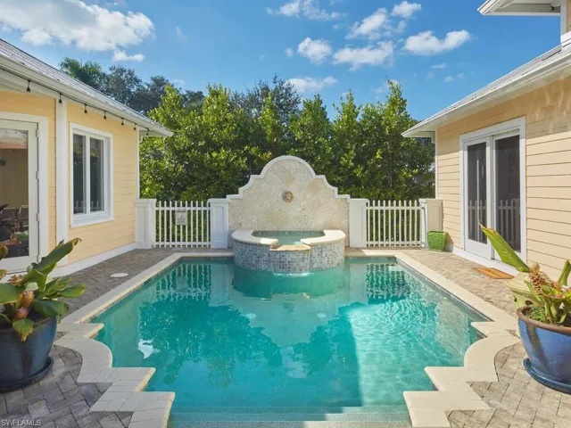 View of swimming pool featuring a patio area and a pool with connected hot tub