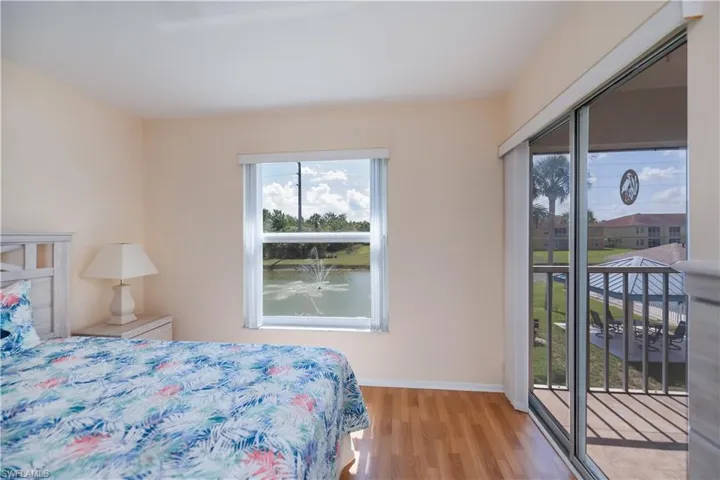 Bedroom featuring access to outside, light wood-style flooring, and a water view
