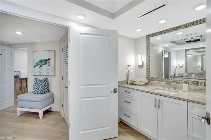 Bathroom with visible vents, vanity, baseboards, a raised ceiling, and backsplash