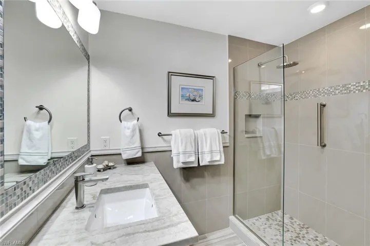 Full bathroom with recessed lighting, tile walls, a shower stall, and vanity