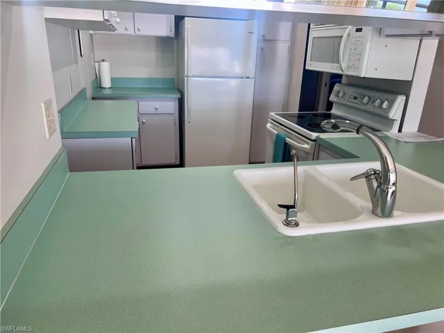 Kitchen featuring white appliances and light countertops