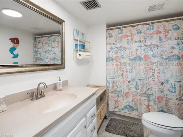 Bathroom with a shower with curtain, vanity, and toilet