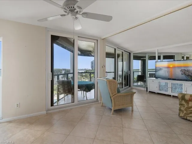 Tiled bedroom featuring floor to ceiling windows, access to exterior, and ceiling fan