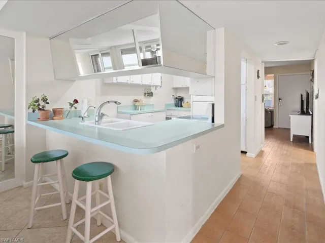 Kitchen featuring sink, a breakfast bar, white cabinetry, stove, and kitchen peninsula