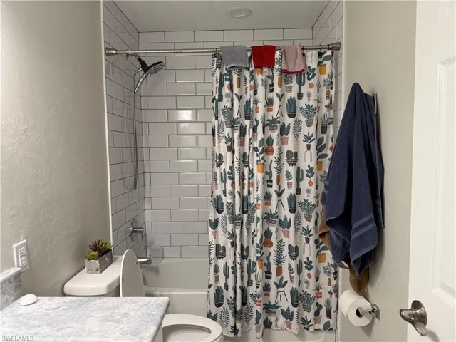 Bathtub and shower combination featuring white subway tile surround, polished chrome shower fixtures, and a recessed ceiling light