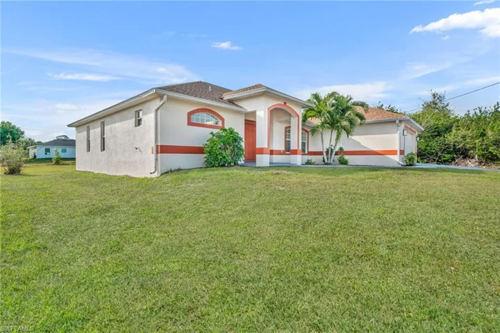 Mediterranean / spanish-style house with stucco siding and a front yard