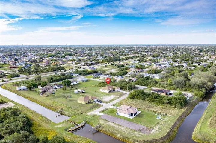 Aerial view of property's location featuring a large body of water and nearby suburban area