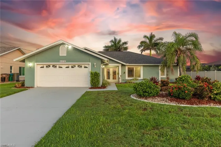 Ranch-style house featuring french doors, an attached garage, concrete driveway, and stucco siding