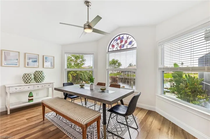 Dining area with vaulted ceiling, light wood-type flooring, and a ceiling fan