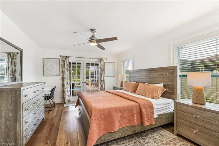 Bedroom with french doors, dark wood-type flooring, access to exterior, and a ceiling fan