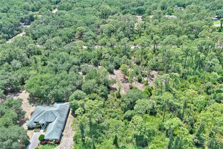 Aerial view of property and surrounding area featuring a heavily wooded area
