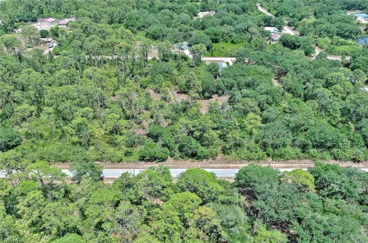Aerial view of property's location with a forest