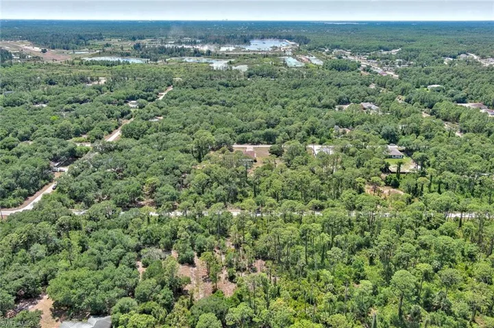 Aerial view of property and surrounding area featuring a forest