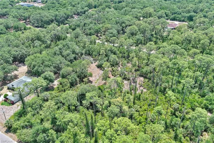 Aerial overview of property's location with a heavily wooded area