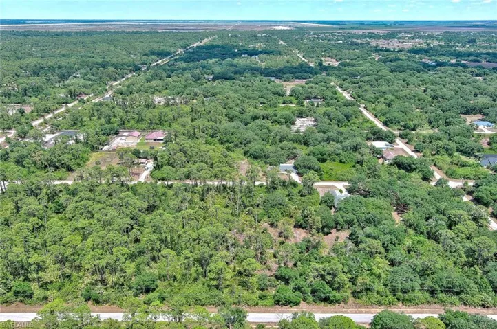 Aerial view of property's location featuring a heavily wooded area