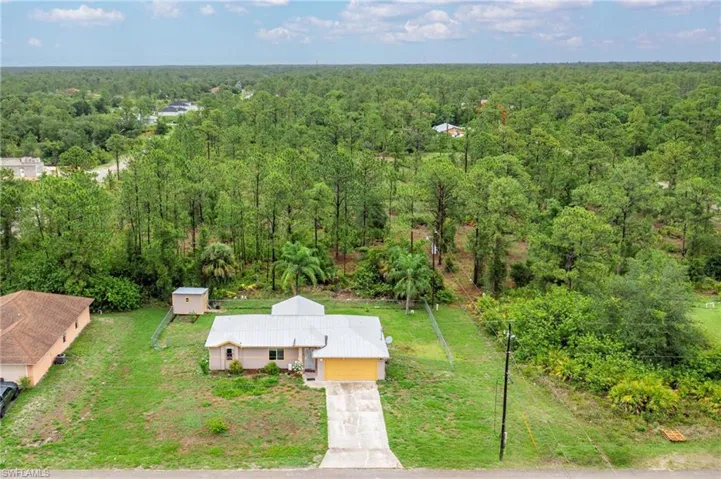 Aerial view of property and surrounding area featuring a heavily wooded area