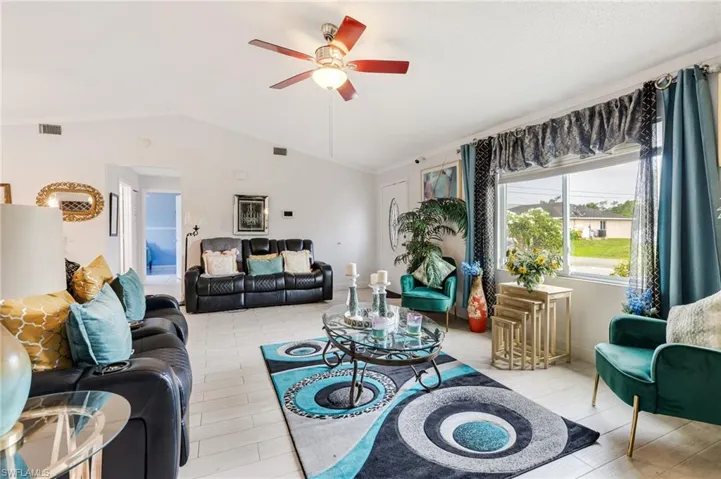 Living room featuring vaulted ceiling and ceiling fan