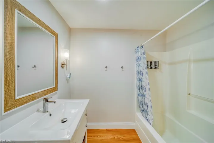 Full bath featuring vanity, light wood-style floors, and shower / tub combo