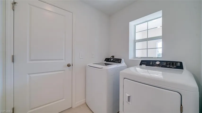 Laundry room with light tile patterned floors and washer and dryer