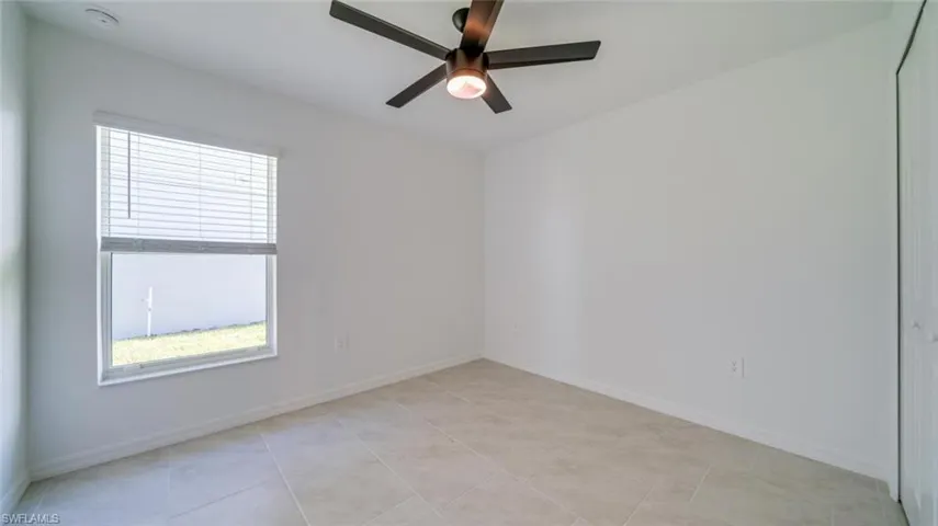 Spare room with light tile patterned flooring and ceiling fan