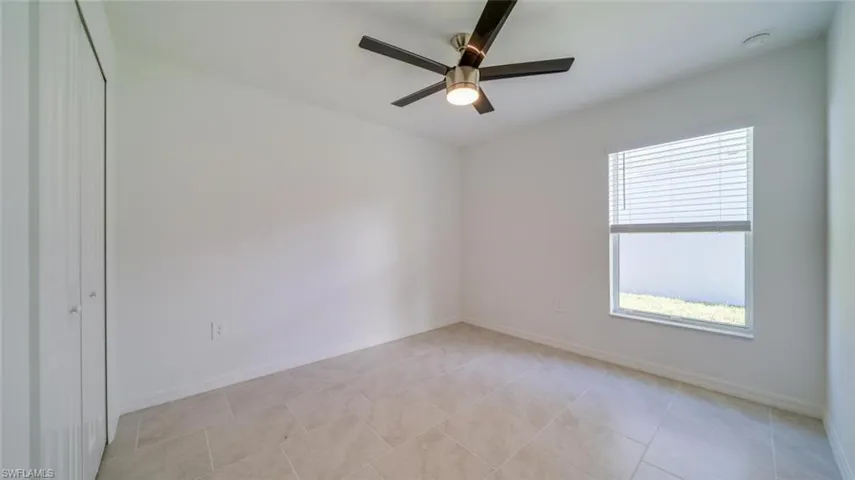 Tiled empty room featuring ceiling fan