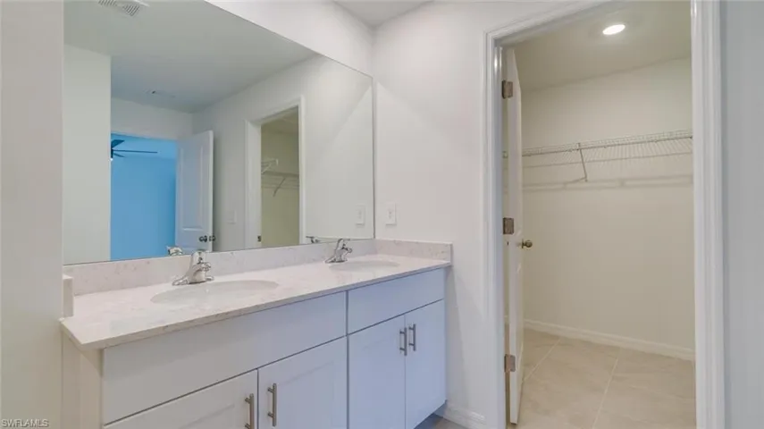Bathroom featuring tile patterned flooring, vanity, and ceiling fan