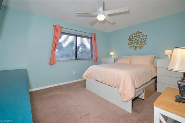 Carpeted bedroom featuring baseboards and a ceiling fan