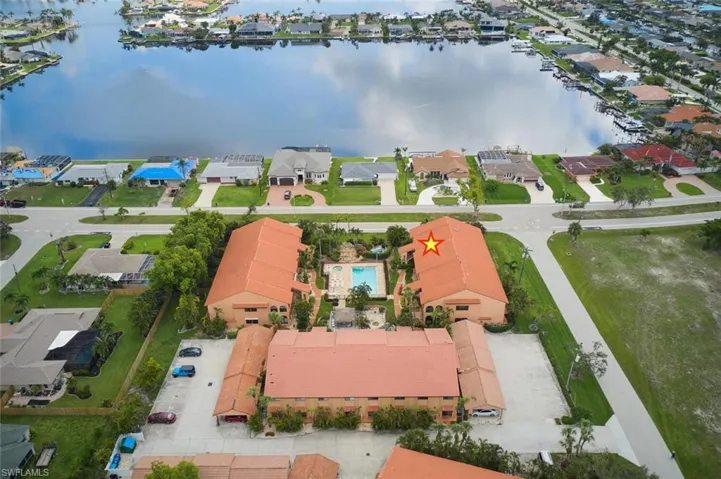 Aerial perspective of suburban area featuring a nearby body of water