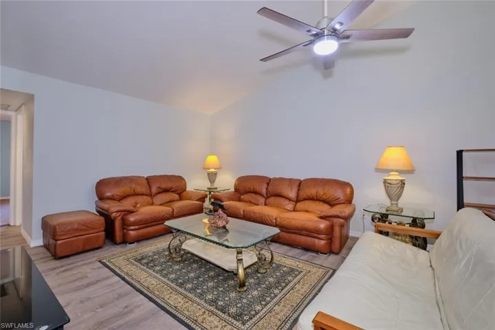 Living area featuring wood finished floors, lofted ceiling, and a ceiling fan