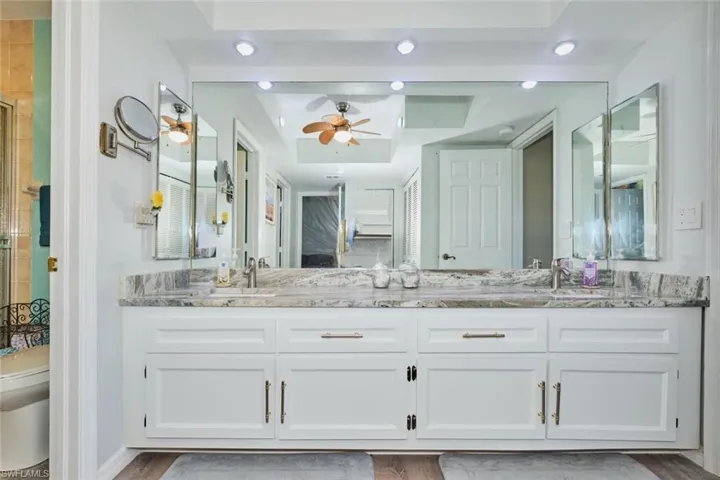 Full bath with double vanity, ceiling fan, recessed lighting, and a shower
