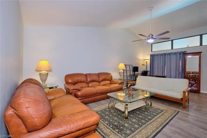 Living area with wood finished floors, vaulted ceiling, and a ceiling fan