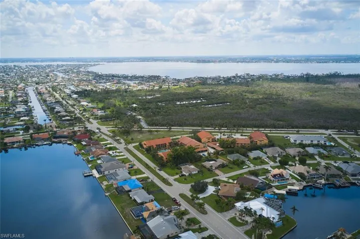 Aerial overview of property's location featuring a large body of water and nearby suburban area
