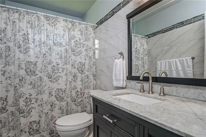 Bathroom with walk in shower, vanity, and toilet