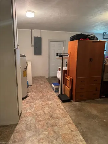 Basement with electric panel, water heater, and washer / clothes dryer