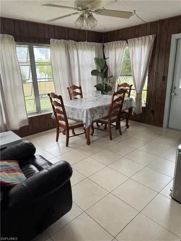 Dining area with plenty of natural light, ceiling fan, light tile patterned flooring, and a textured ceiling