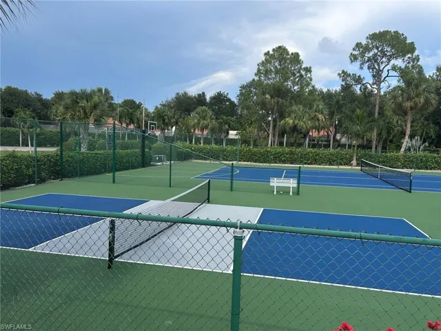 Outdoor recreational courts featuring green and blue surfacing, multiple nets, and green chain-link fencing