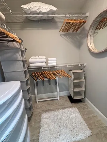 Spacious closet featuring wire shelving, light gray wall paint, and tile flooring