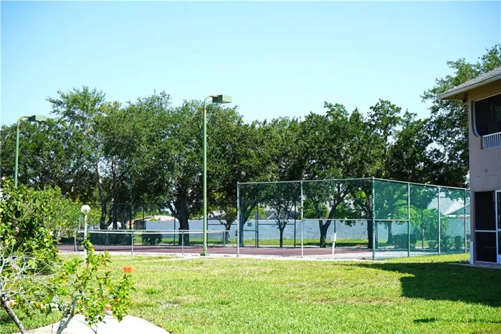 View of sport court featuring a lawn